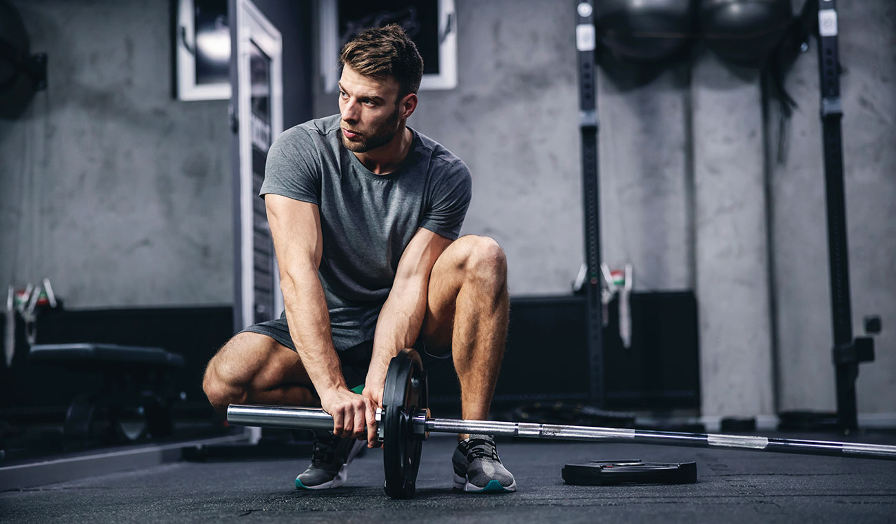 athletic male in a grey t-shirt doing landmines