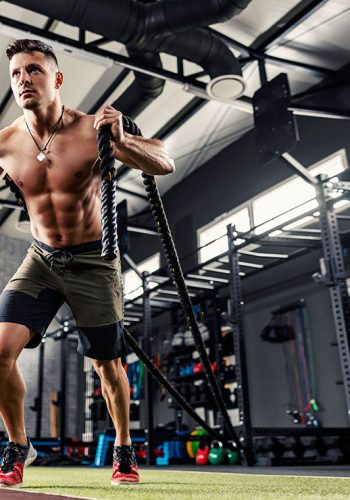 muscular shirtless male holding ropes