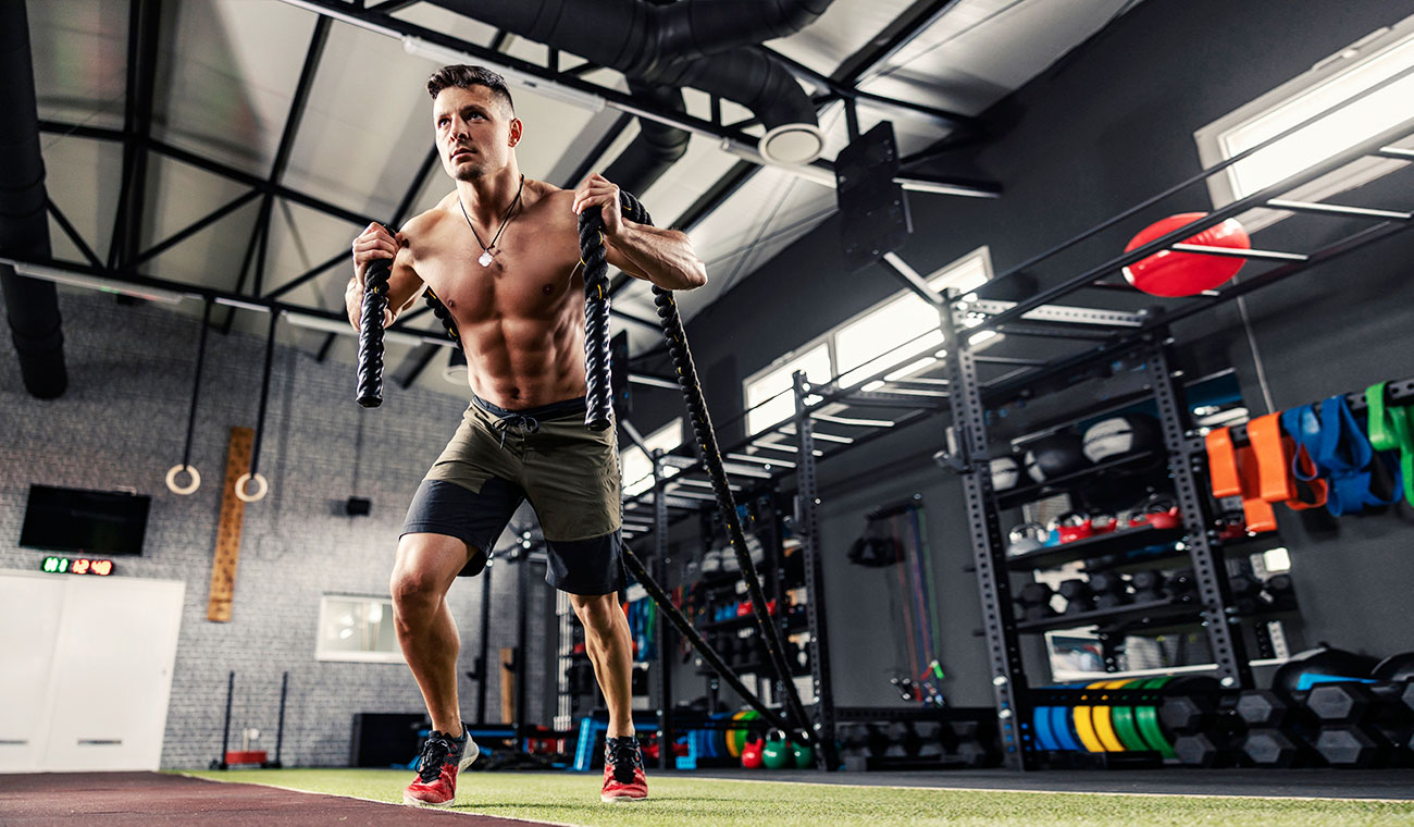 muscular shirtless male holding ropes