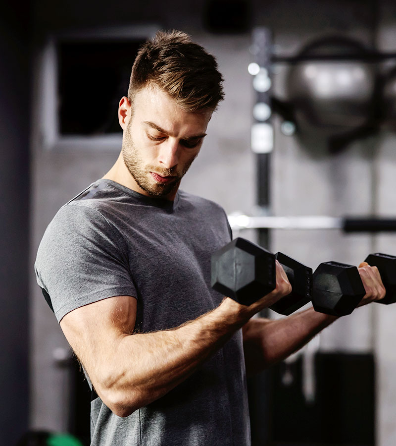 muscular guy in grey t-shirt doing bicep curls