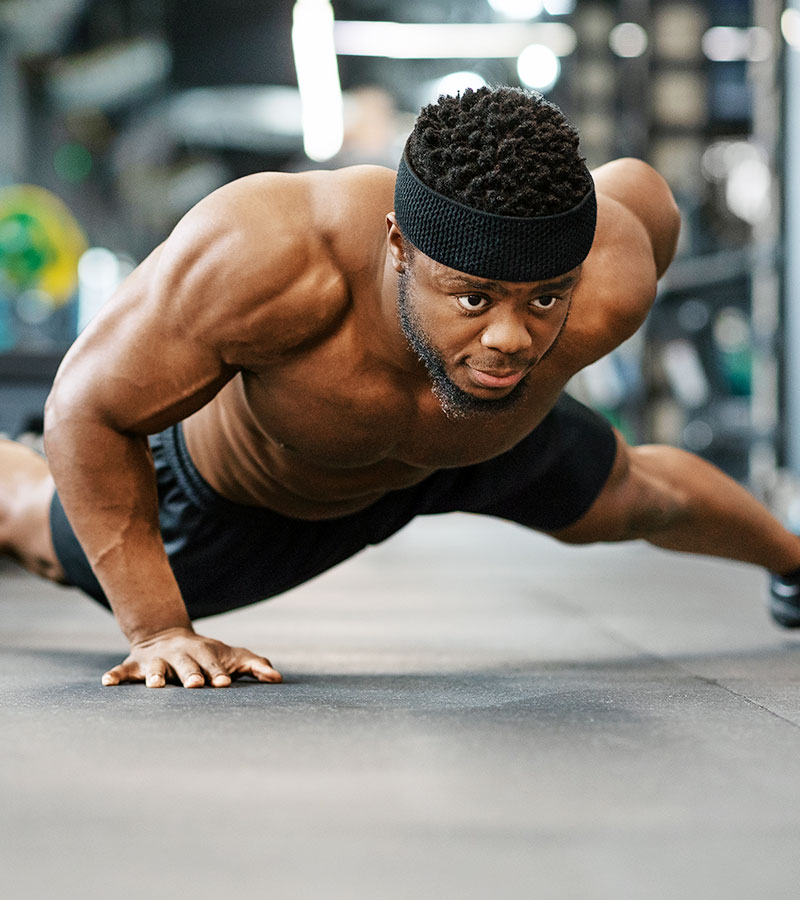 athletic guy in black headband doing a one-handed push up