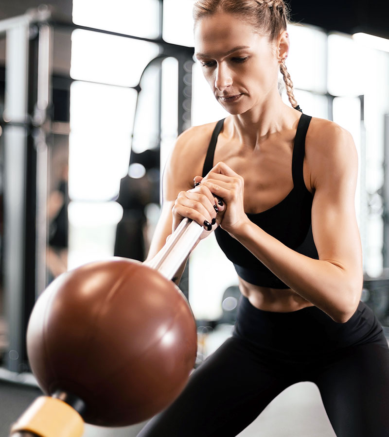 athletic women doing the landmine workout with a medicine ball