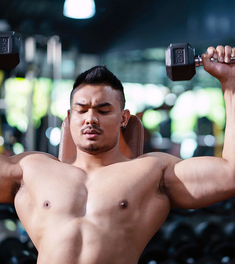 muscular guy doing shoulder presses