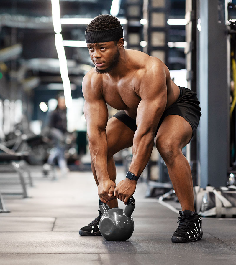 muscular guy doing a kettle ball swing